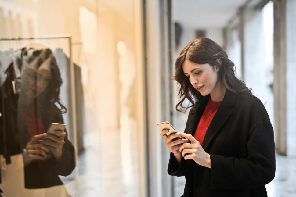 Free Image of Young Woman Checking Her Phone While Doing Shopping In Mall 