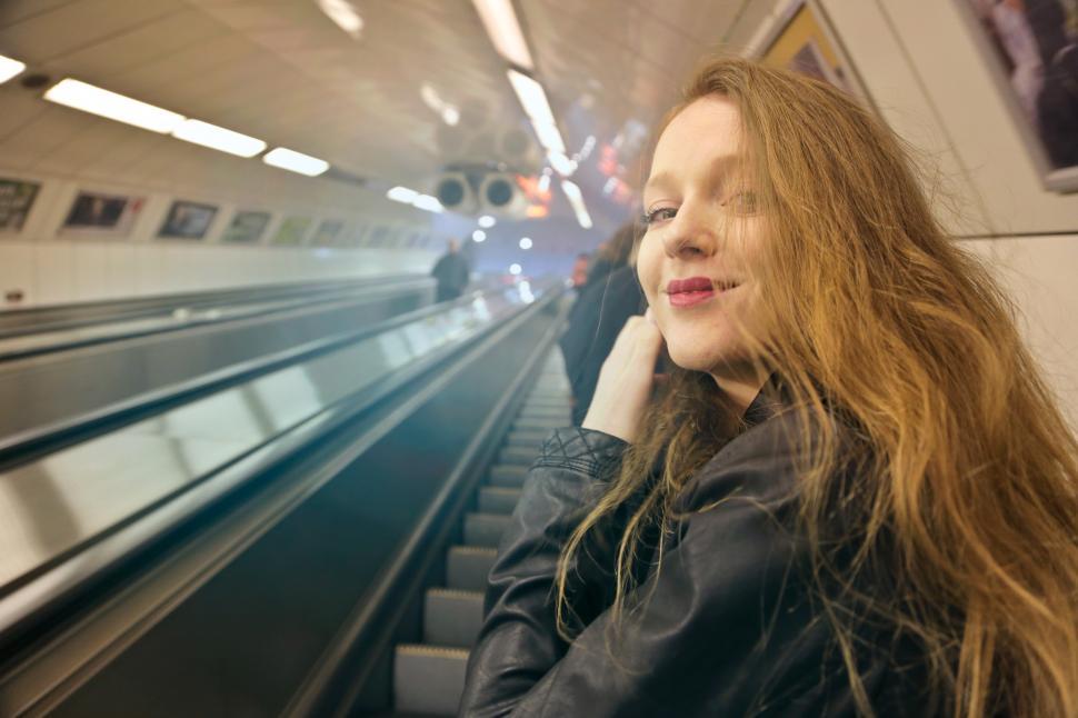 Free Image of Young Woman In Black Leather Jacket Using Escalator 