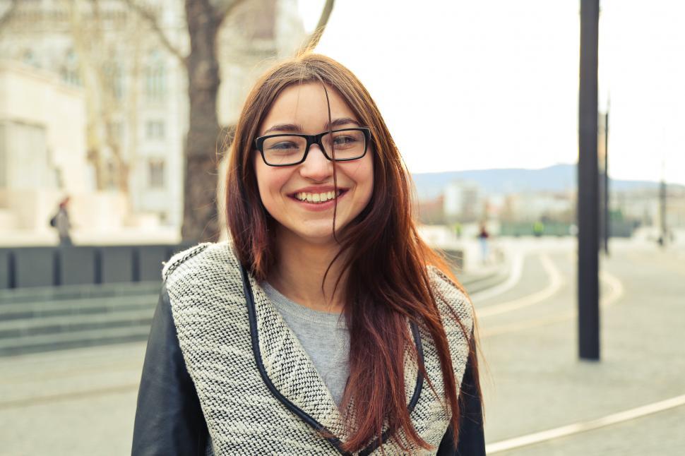 Free Image of Portrait Of Young Smiling Woman In Black And White Woolen Jacket 