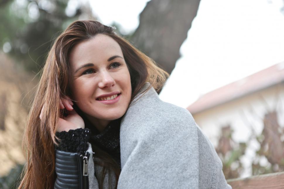 Free Image of A young blonde woman smiling in the outdoors 