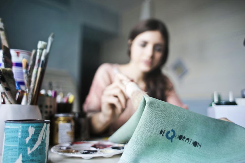 Free Image of A young woman painting with a brush in her hand 