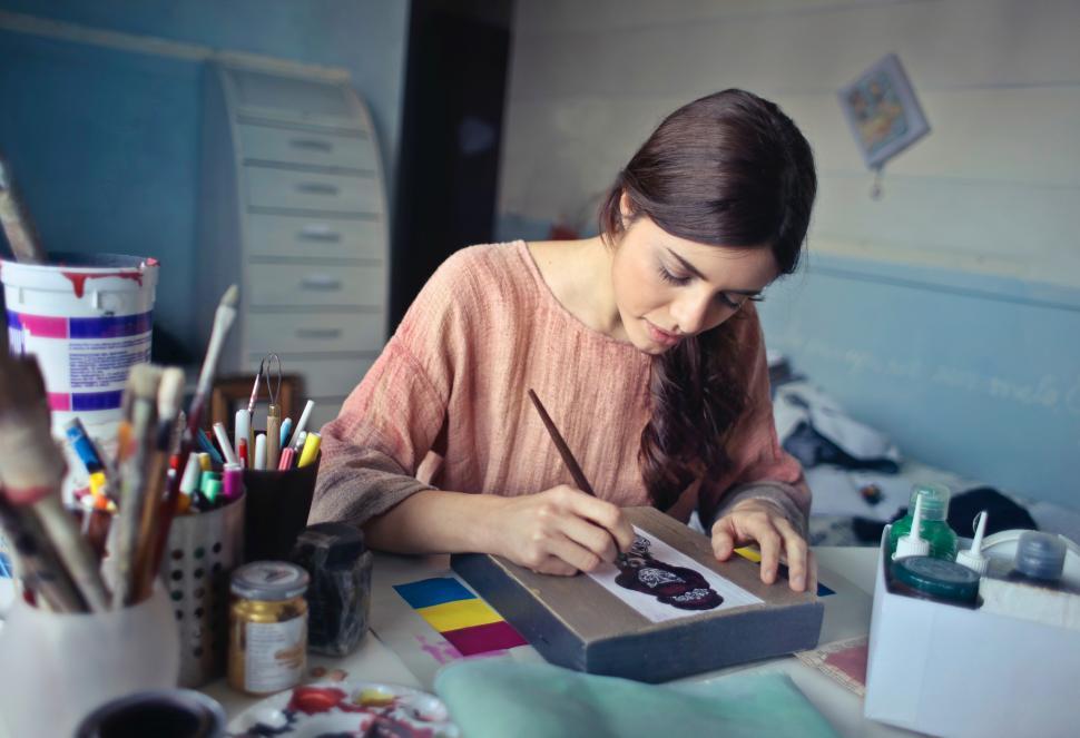 Free Image of A young woman painting with a brush in her hand 