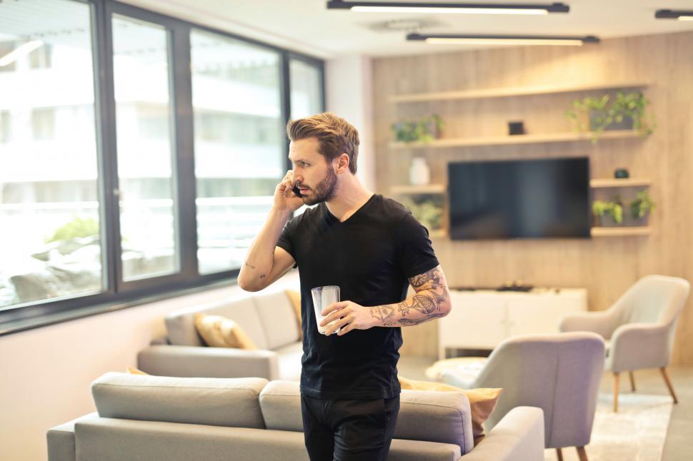 Free Image of Man on the phone in the living room 