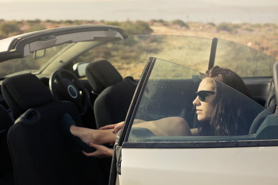 Free Image of Young Woman In Black Miniskirt And Sunglasses Sitting In Convert 