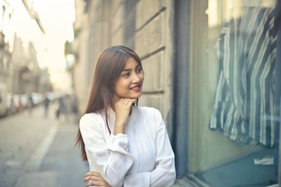 Free Image of Young Asian Woman In White Shirt Seen With Hand On Chin On The R 