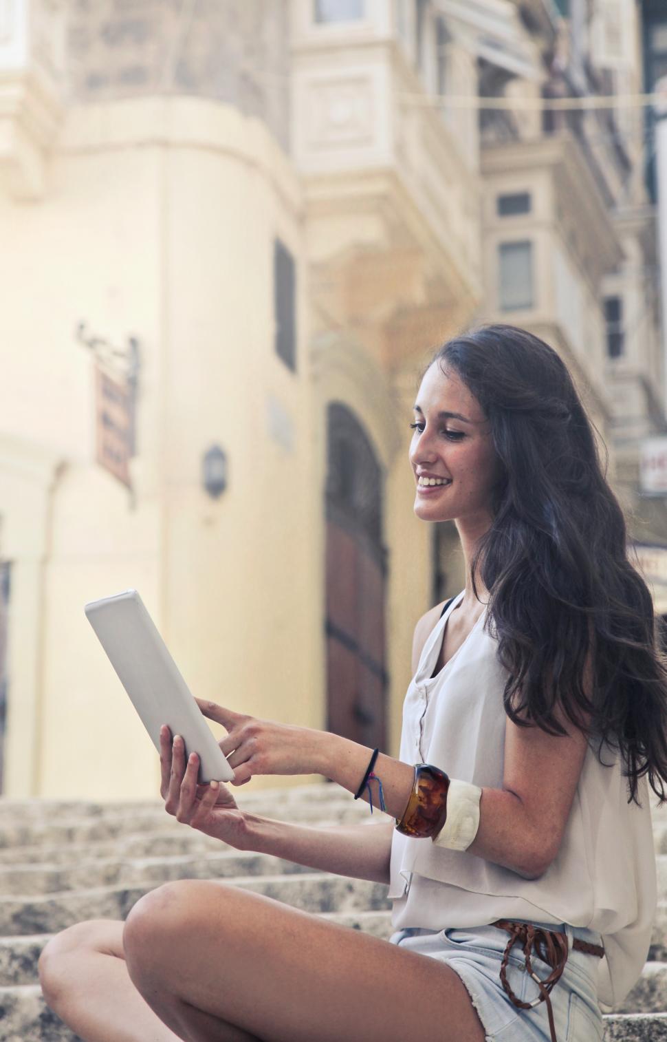 Free Image of A young brunette woman looking at her tablet screen 