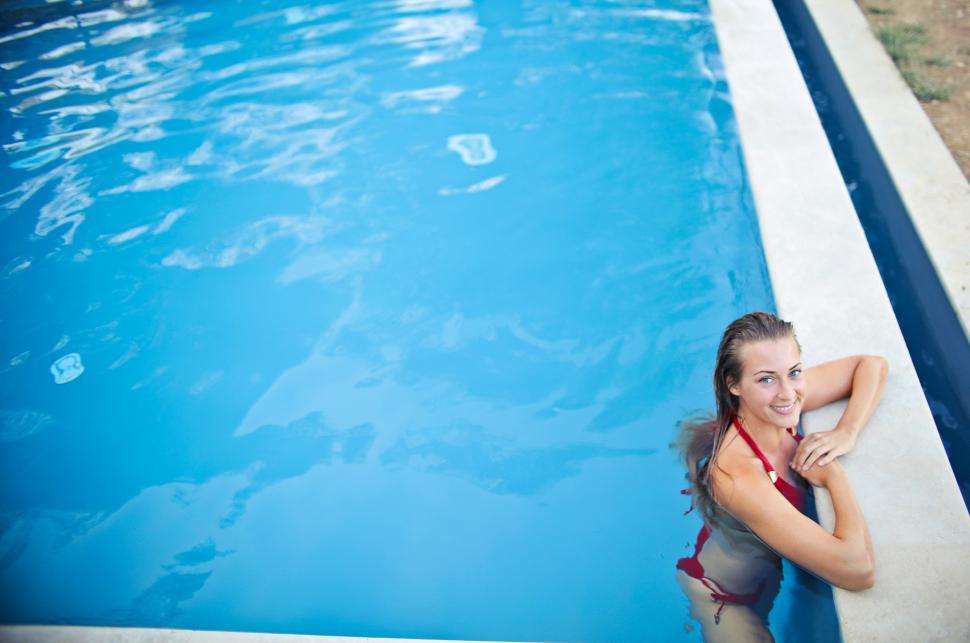 Free Image of A young blonde woman wearing red bikini standing in the swimming 