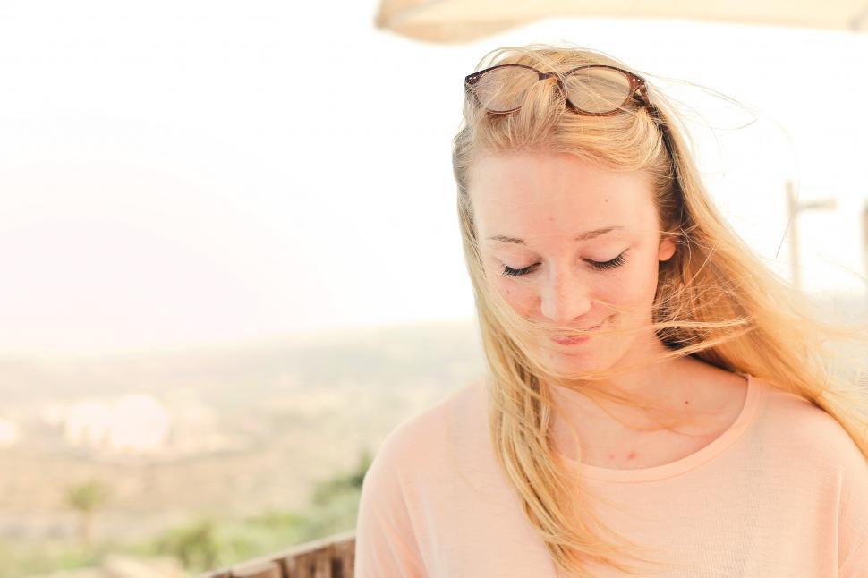 Free Image of A blonde young woman wearing peach dress posing outdoors 