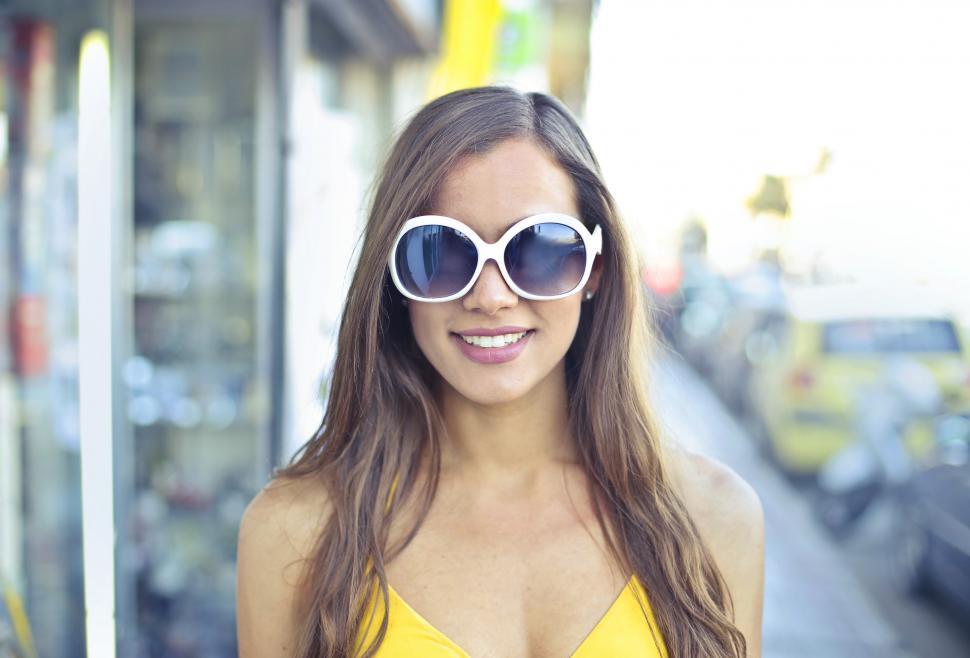 Free Image of A young blonde woman wearing a yellow dress posing outdoors 