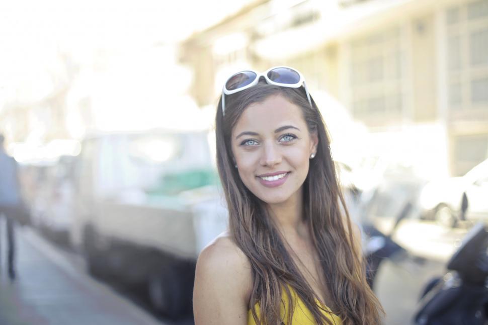 Free Image of A young blonde woman wearing a yellow dress posing outdoors 