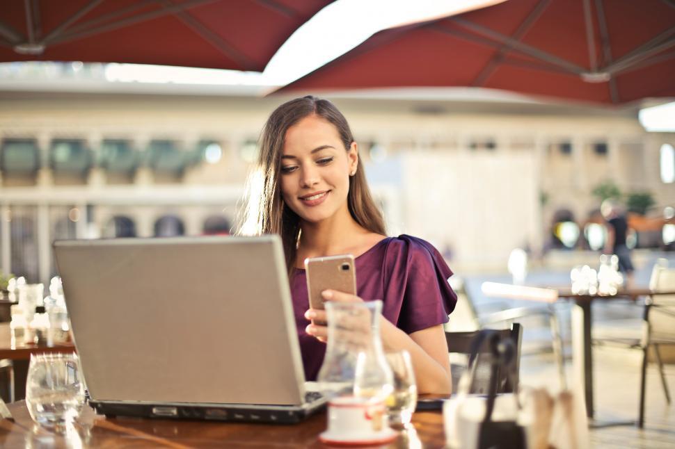 Free Image of A young blonde woman looking at her mobile phone screen in a res 