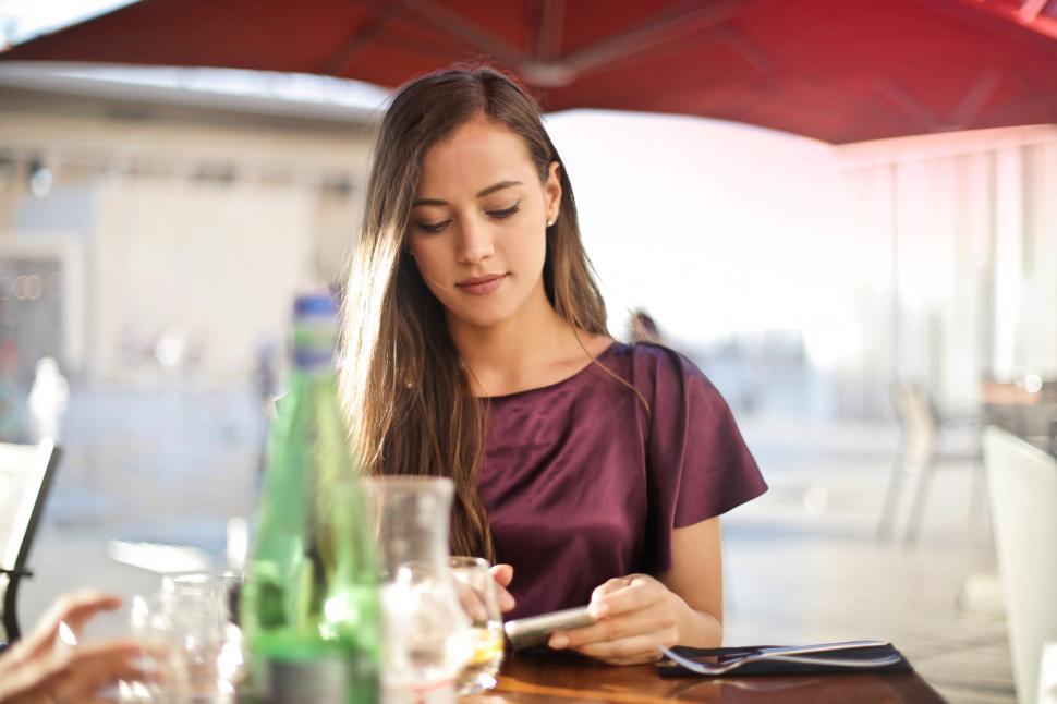 Free Image of A young blonde woman looking at her mobile phone screen in a res 