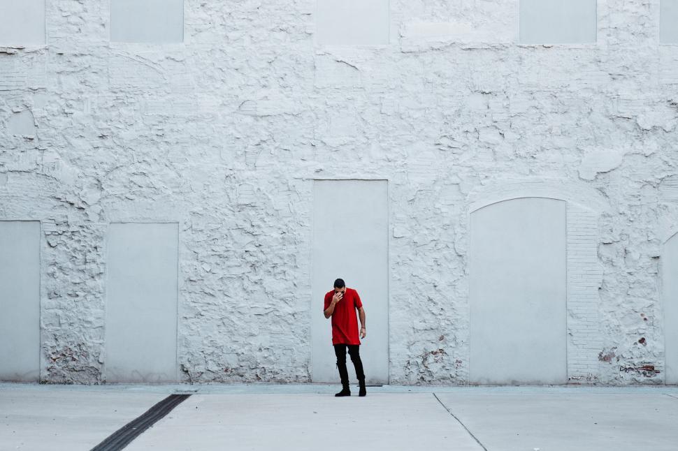 Free Image of A fashionable man by textured wall 