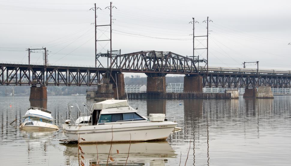 Free Image of Storm Damaged Boats By Railroad Bridge 