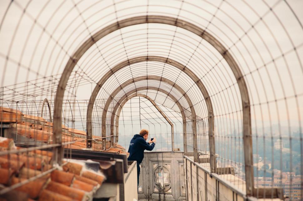 Free Image of A young caucasian man on a rooftop walkway 