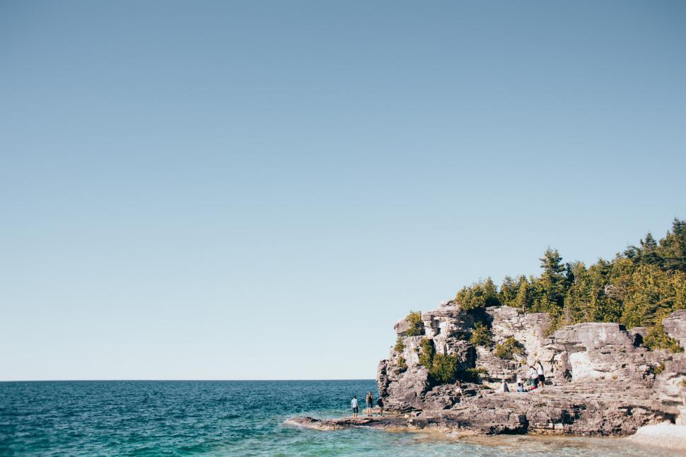 Free Image of Hikers on the rock near bay of ocean 