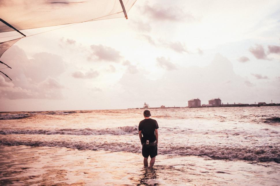 Free Image of A young caucasian man wading in sea water 