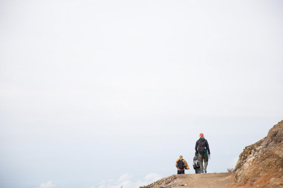 Free Image of Hikers walking on a gravel hill 