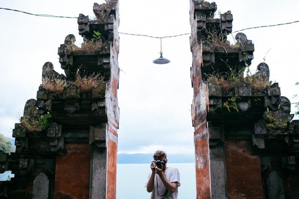 Free Image of A traveler photographer at a temple s entrance 