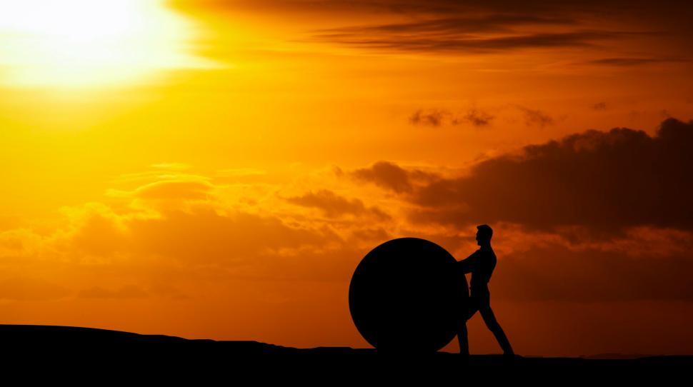 Free Image of man pushing rock ball  