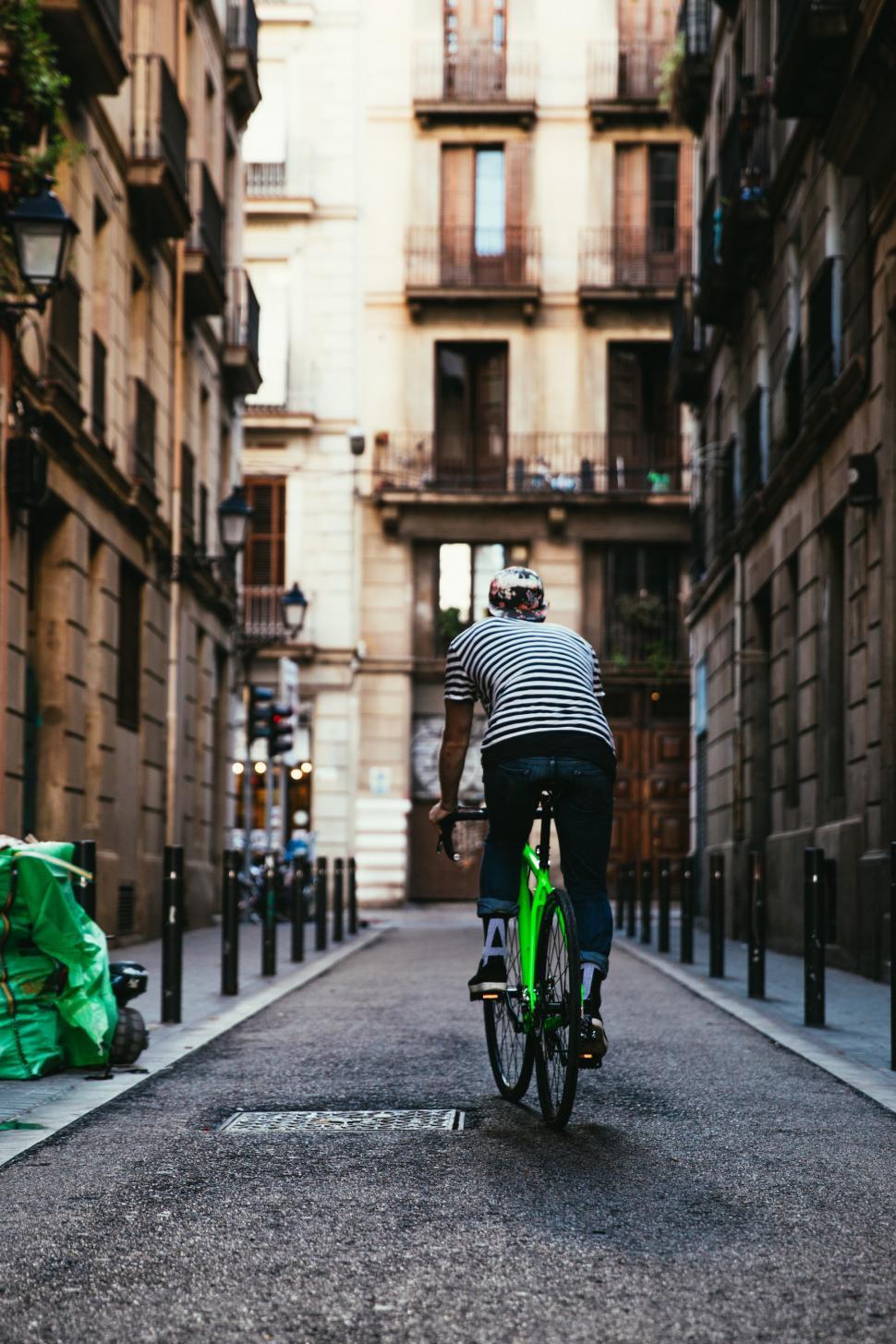 Free Image of Rear view of a biker riding a green bicycle 