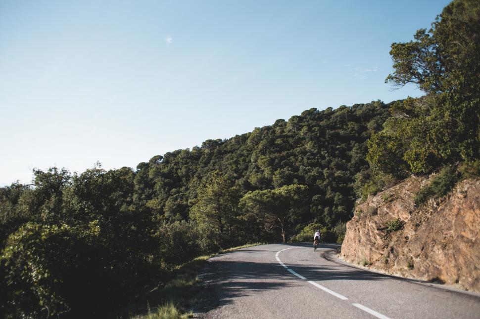 Free Image of Country road cyclist on a curvy road 