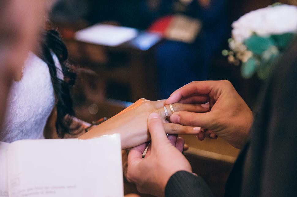 Free Image of Groom putting wedding ring on the bride s finger 