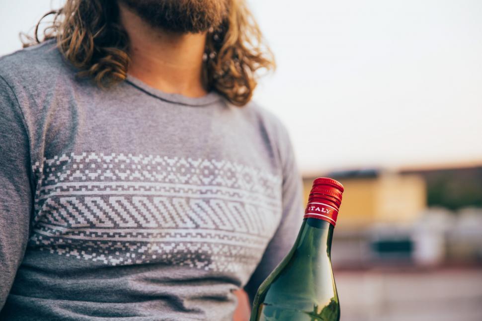 Free Image of A bearded caucasian man holding an Italian bottle 
