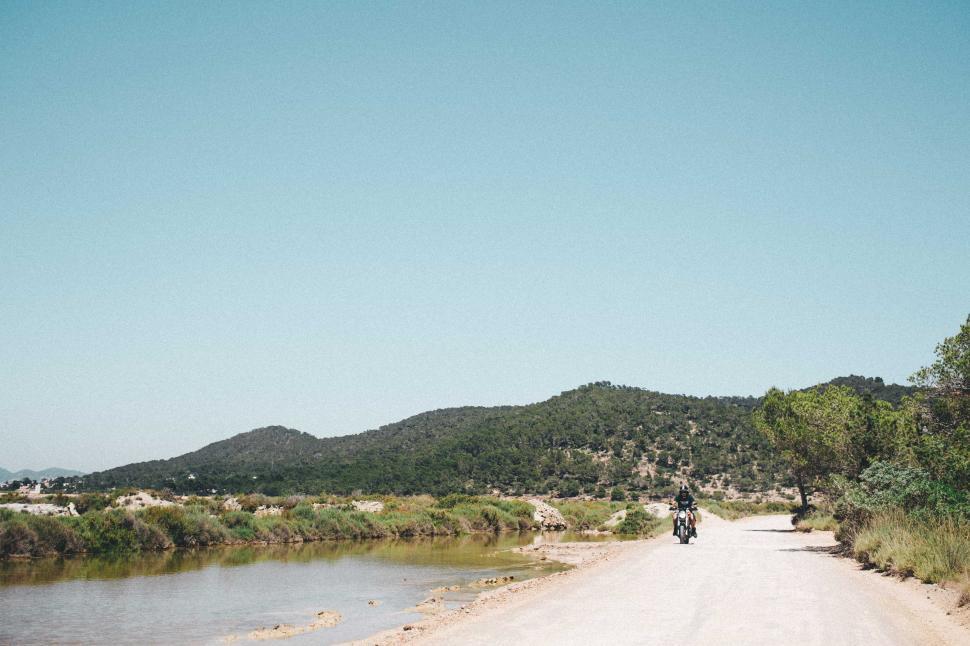 Free Image of A young motorcyclist on a hilly road 