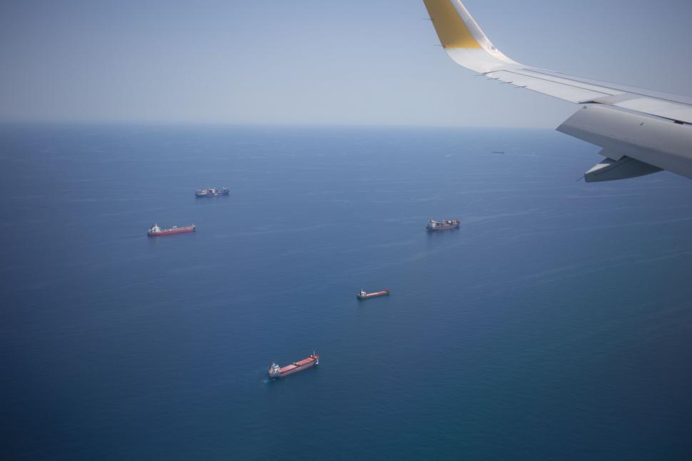Free Image of Aerial view of ships in the ocean from the airplane window 