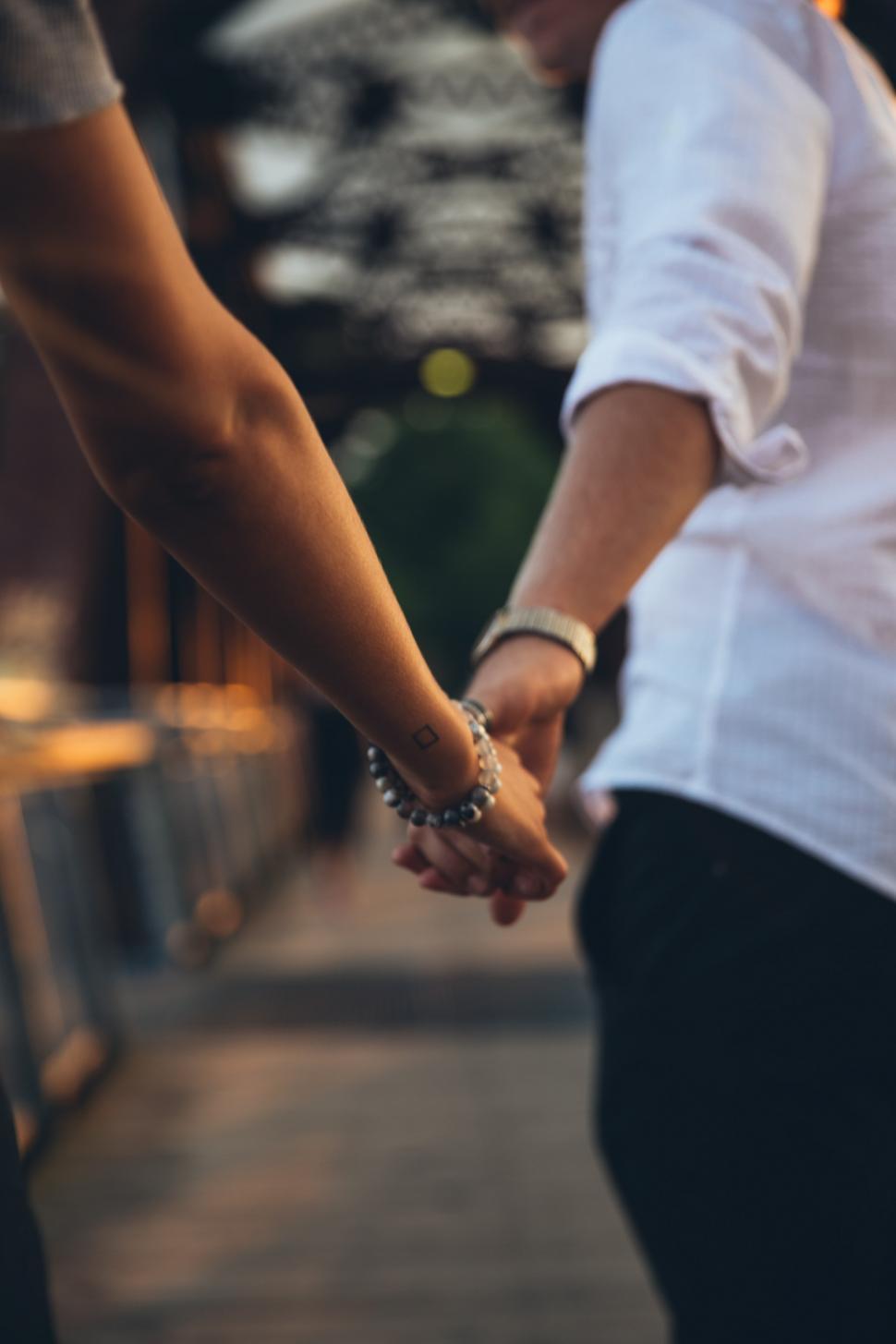 Free Image of A young caucasian couple holding each other s hands 