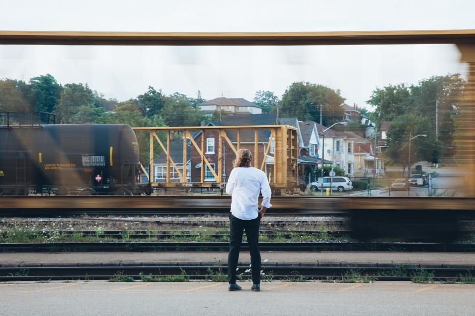 Free Image of A young caucasian man standing near passing train 