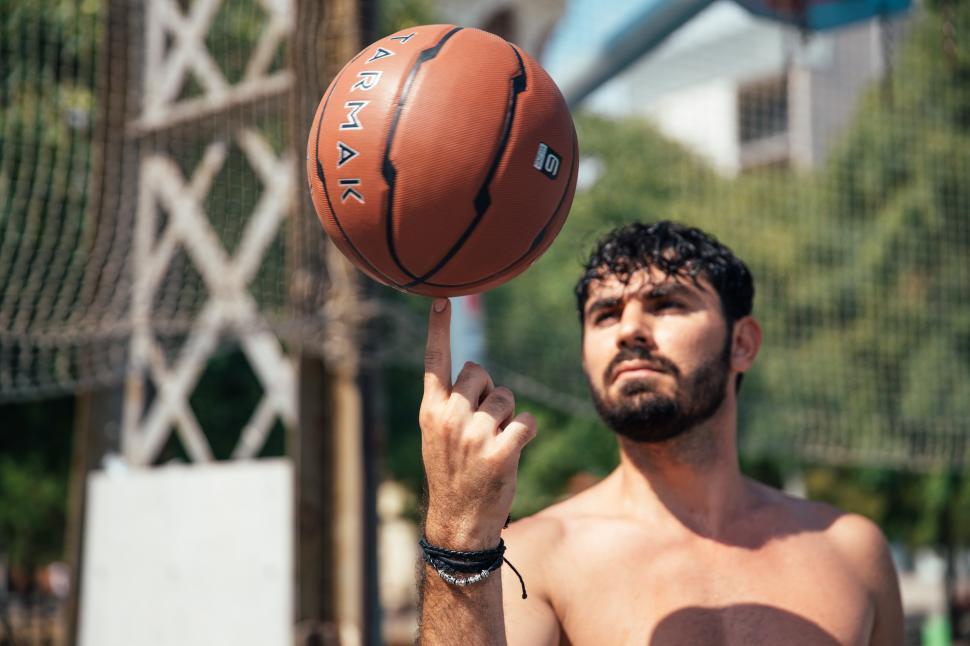 Free Image of A young man spinning basketball on his finger 