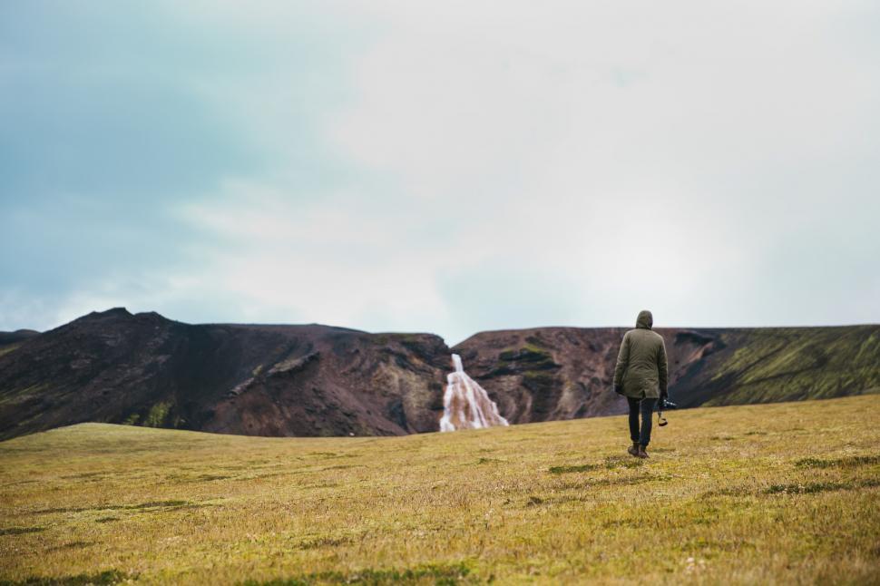 Free Image of A hiker on a green field near glacier 