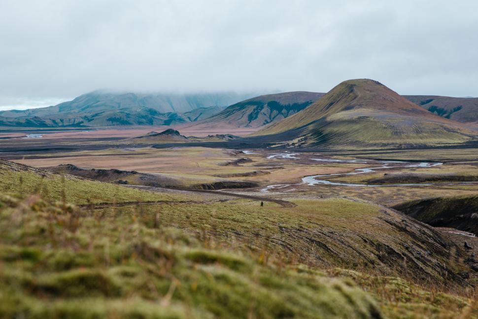 Free Image of A hiker on a moss-grown volcanic hill 