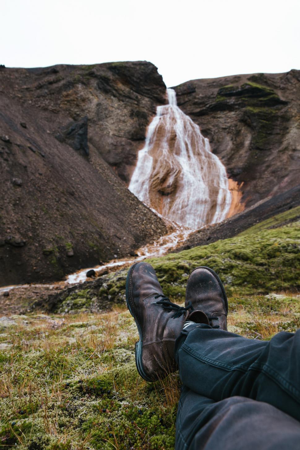Free Image of Feet relaxing on moss grown rock 
