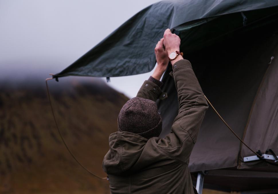 Free Image of A young caucasian man setting up tent 
