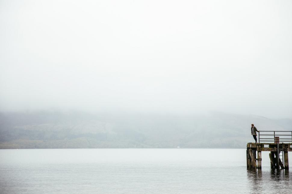 Free Image of A caucasian man leans over the edge of the pier 