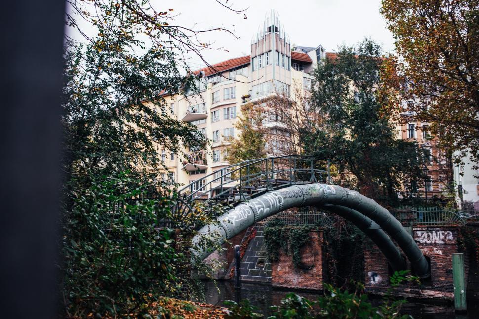 Free Image of A curved metal pipeline over an urban river 