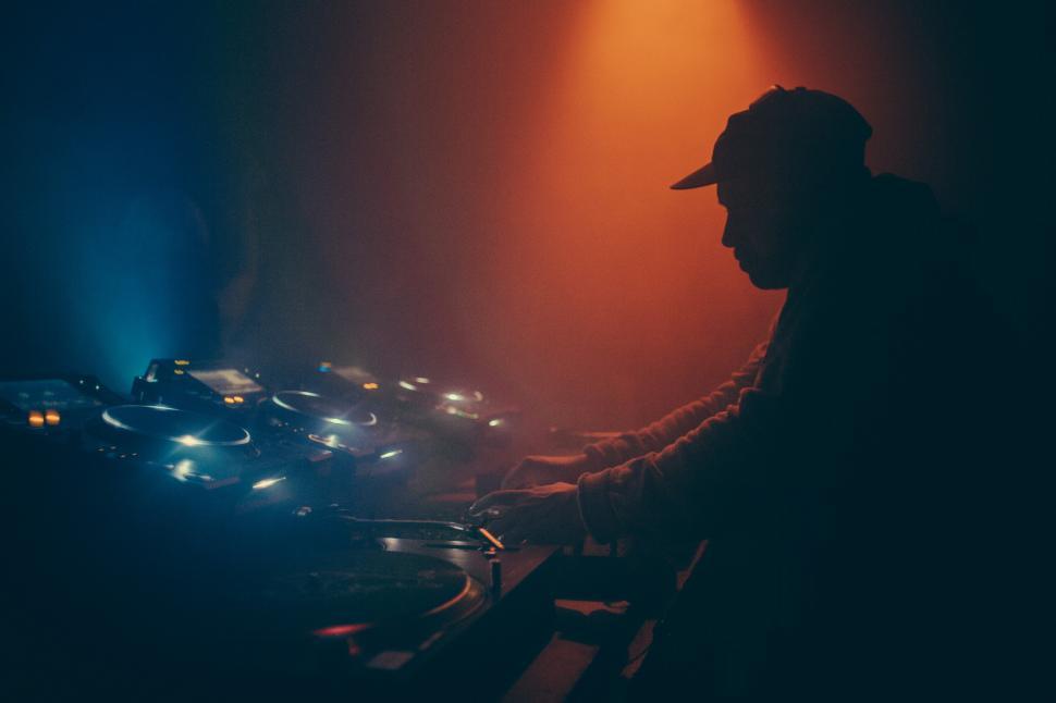 Free Image of A DJ operating a music mixing console 