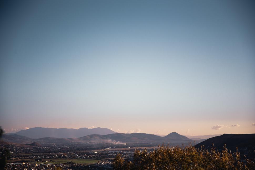 Free Image of Pastel sky over a green village, sunset 