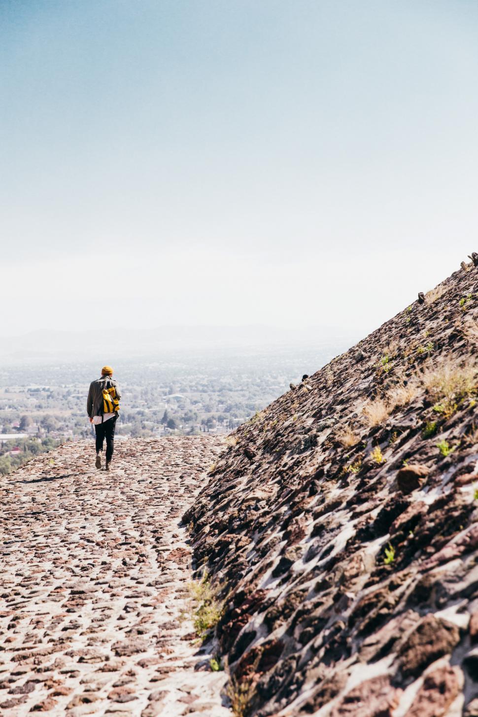 Free Image of A man walking on historic stone tomb 