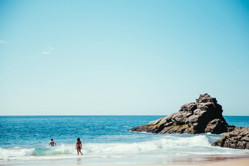 Free Image of A young Caucasian man and a woman swimming in the ocean 