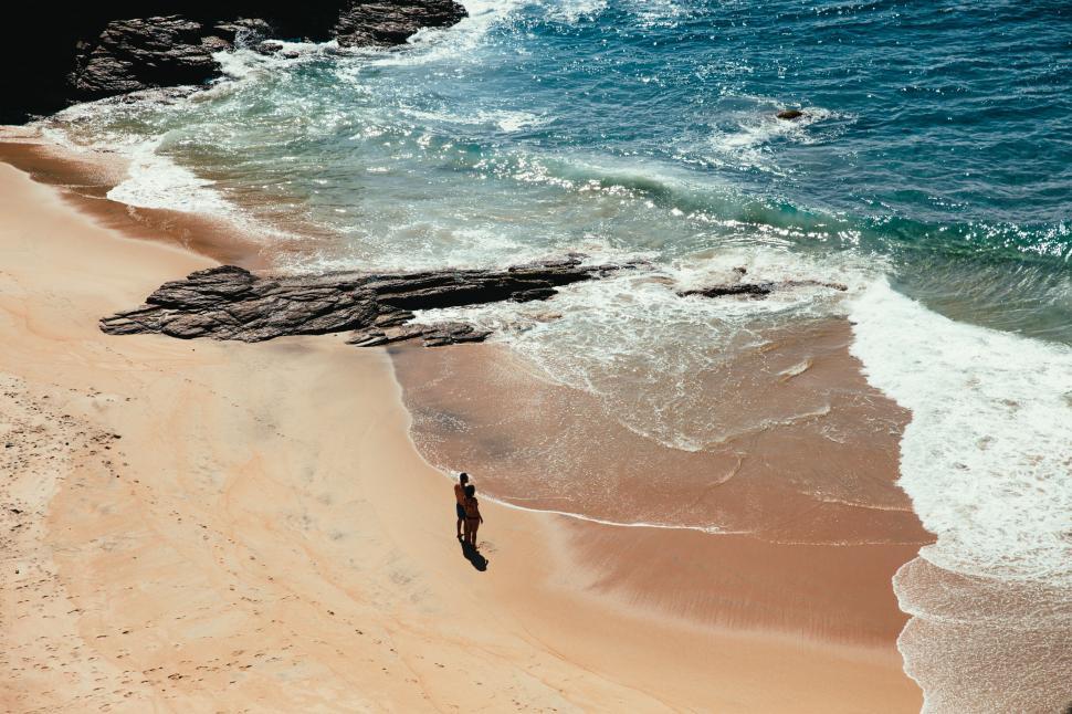 Free Image of A couple standing on the beach 