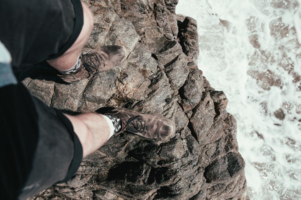 Free Image of Feet hanging over the edge of a rock 