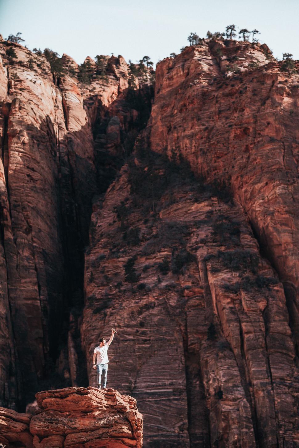 Free Image of A young caucasian man standing on a layered rock 