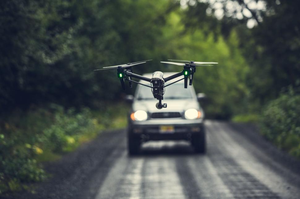 Free Image of A drone flying flying over the road 