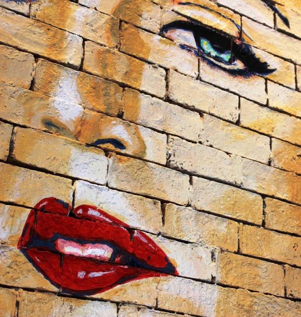 Free Image of Woman's face painted on a brick wall  