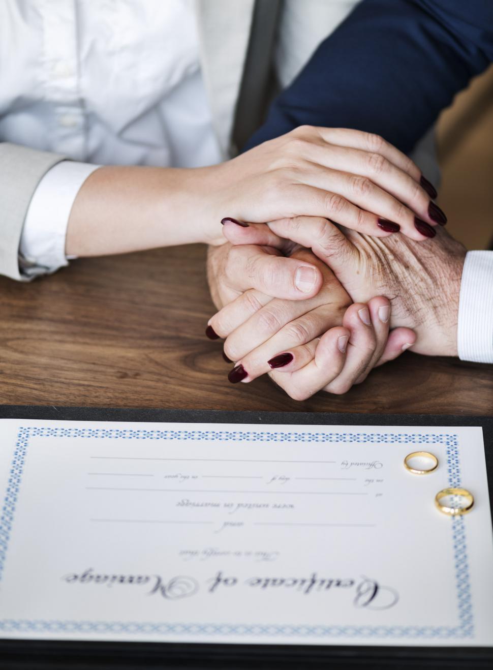 Free Image of Close up of a newly wed couple s hands stacked together 