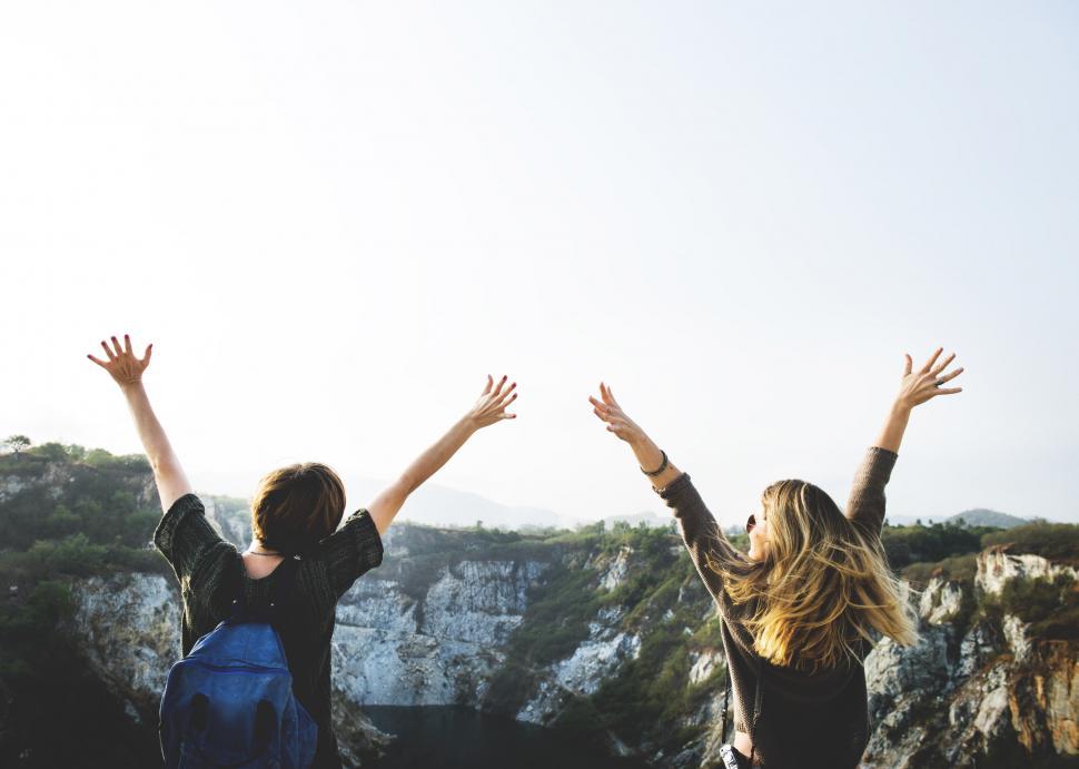 Free Image of Two young caucasian female hikers with hands up 